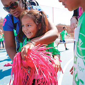 A young girl plays with a pom-pom at Day for Kids