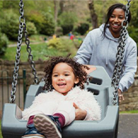 Women pushing a child on a swing