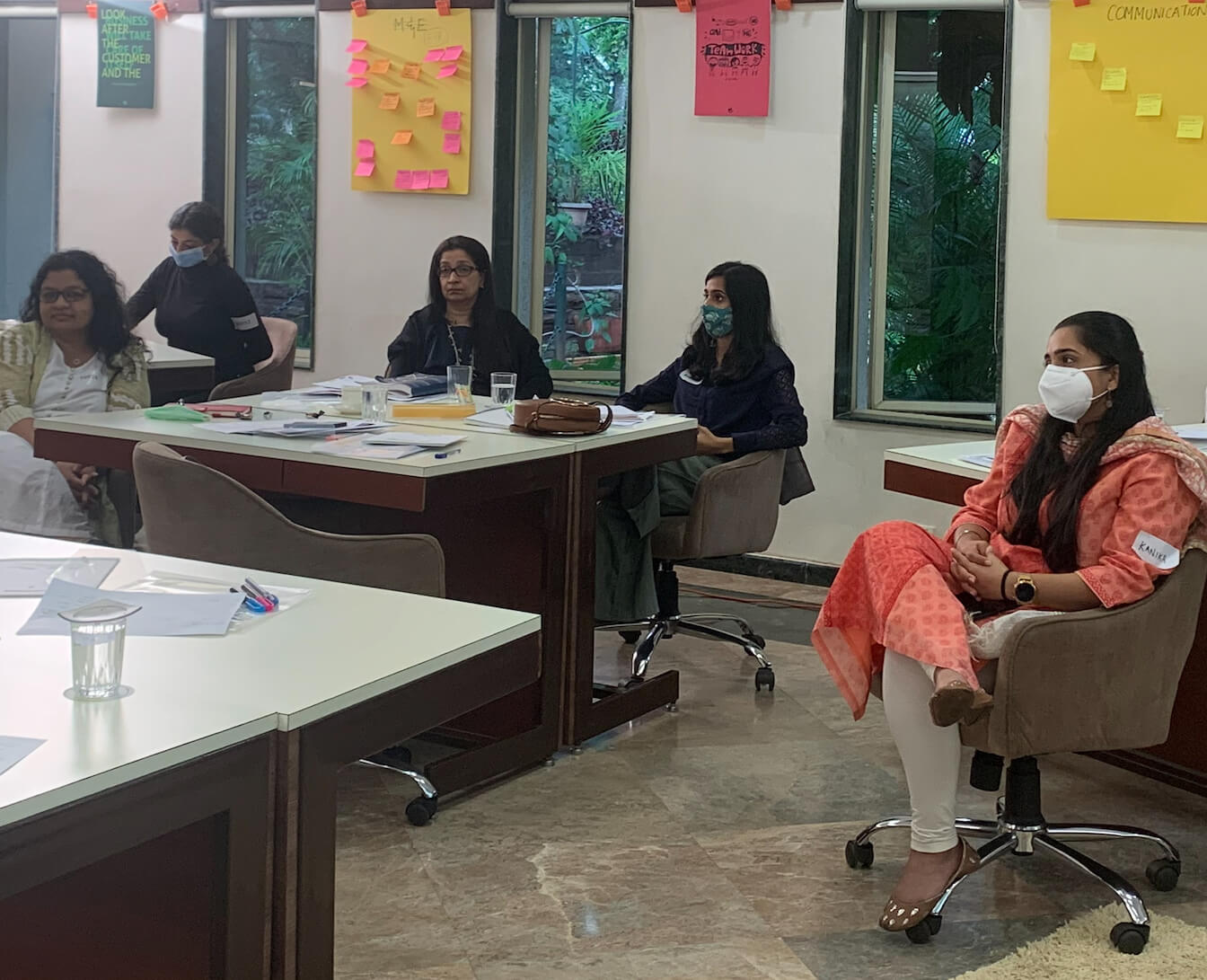 People seated at tables in an office setting