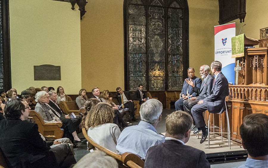 Three people speaking to an audience