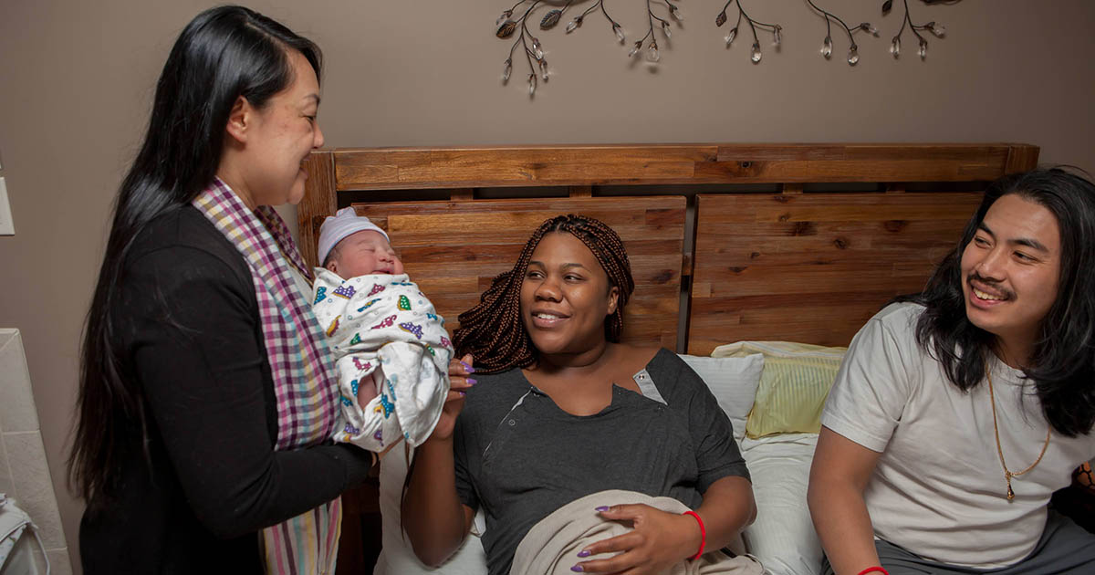 young family with baby and midwife