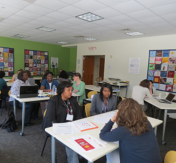 Adults collaborating around workstation tables