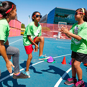 Three girls hang out on a basketball court at Day for Kids