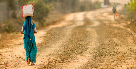 Indian woman walking along dirt road