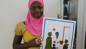 Mariama Diao with Tostan, holding a picture